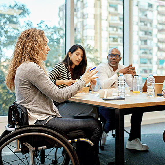 Group of people sat around a desk working together