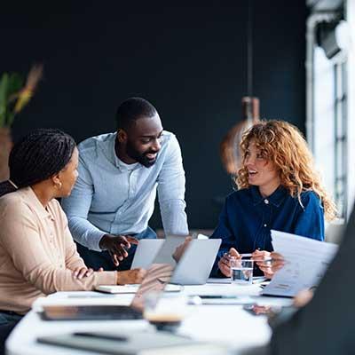 Procurement team of three working together in office at table